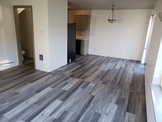 Large great room with new plank flooring on main level - 504 Alder Plz