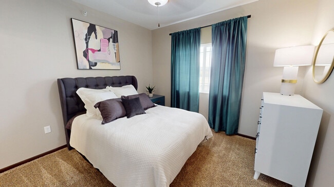 The primary bedroom in The Hub floor plan features lush carpet, a large window, and en suite bathroom.