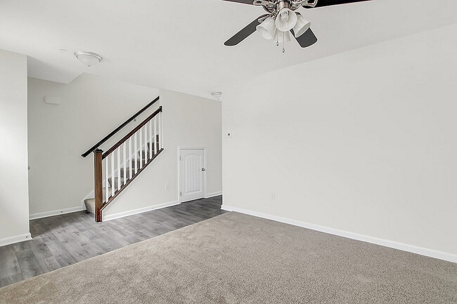 Experience comfort and style in this open, airy living space featuring a sleek staircase.
