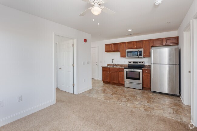 Carpeted living room towards kitchen.