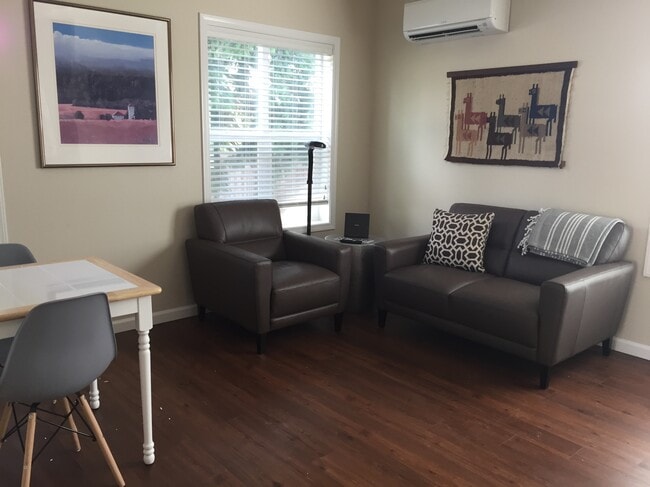Living room with leather furniture. Dining table next to kitchen pass-through.