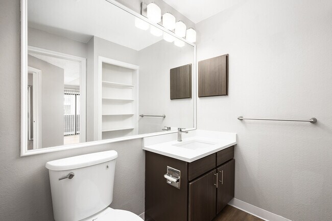 Contemporary bathroom featuring a sleek vanity with ample mirror space, elegant fixtures, and modern lighting.