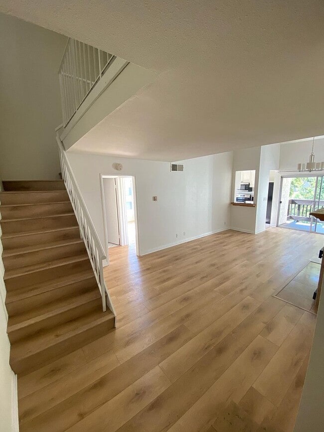 Bright top-floor living room with hardwood floors and open loft above - 8305 Summertime Ln Unit 8305
