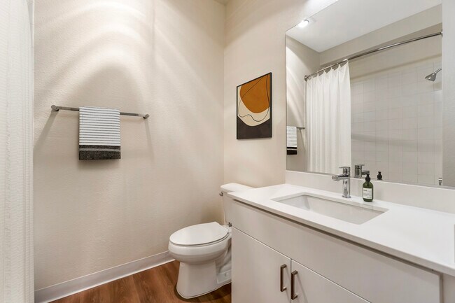 Renovated Package I bath with white quartz countertop, white cabinetry, and hard surface flooring