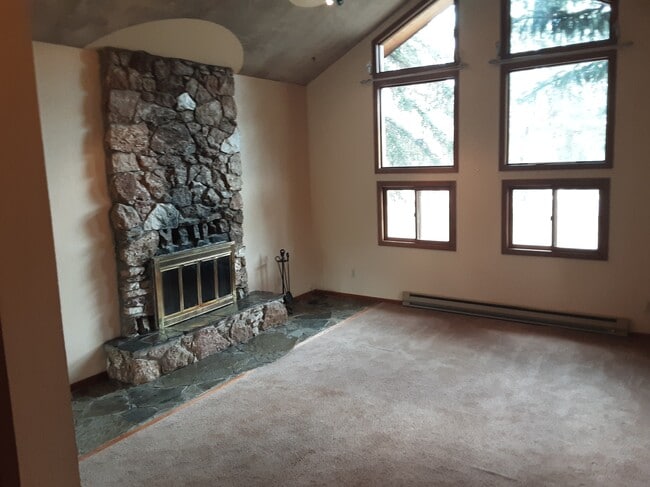 Living room with stone fireplace - 3943 Stevensville River Rd Unit B