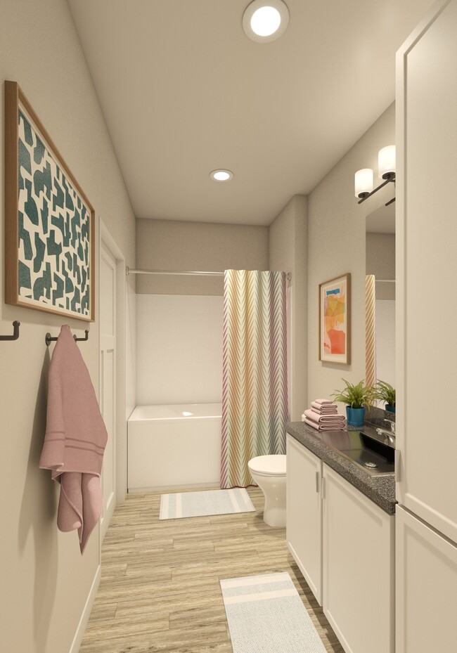 Greenwood Commons apartment bathroom showing a sink, mirror, bathtub, and overhead lighting. - Greenwood Commons Apartments