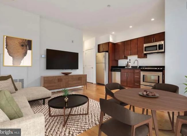 The spacious living area can easily fit a dining set, a couch, coffee table, TV, and storage. - 2910 Georgia Ave NW Unit 205