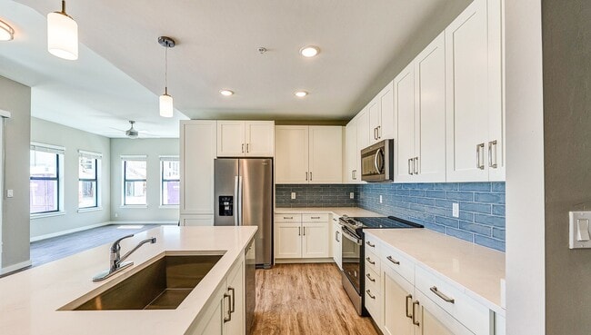 Imperial Crossing Luxury Apartment Homes unit showing a modern kitchen with stainless steel appliances and white cabinets.