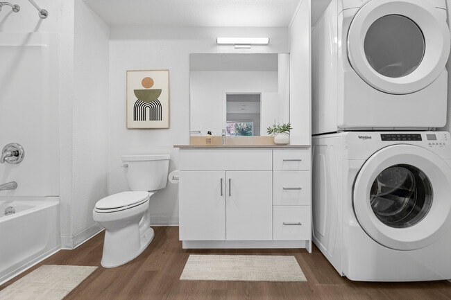 Renovated Package bath with beige quartz countertops, white cabinetry, and hard surface flooring