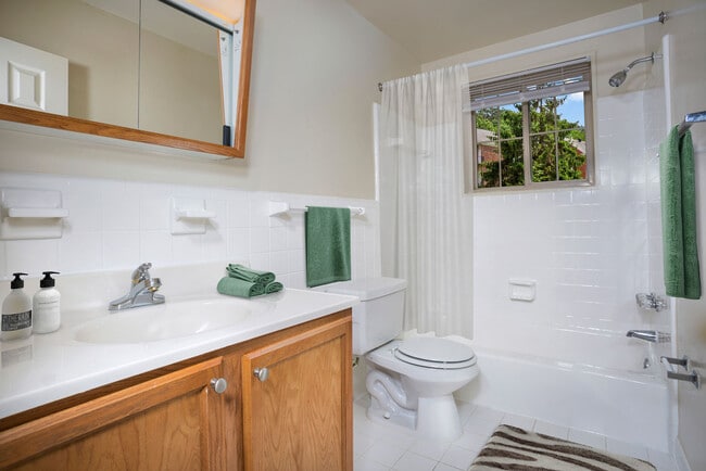 Bath with tile surround at Whitehall Square Apartments in Suitland, MD