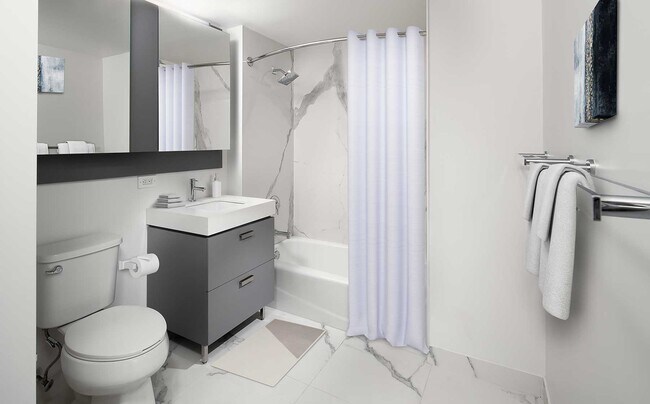 Signature Collection bath with quartz stone countertop and porcelain tub surrounds and flooring