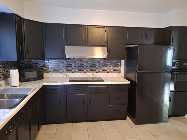 Updated eat-in kitchen with new refrigerator and induction cooktop - 9217 Frankstown Rd Townhome