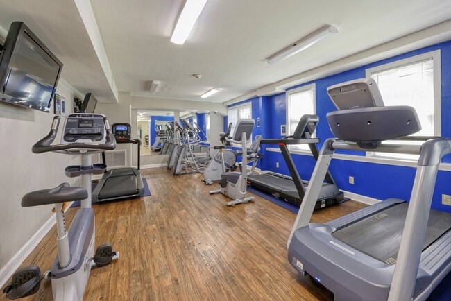 a gym with cardio equipment and treadmills - Park Crest Apartments