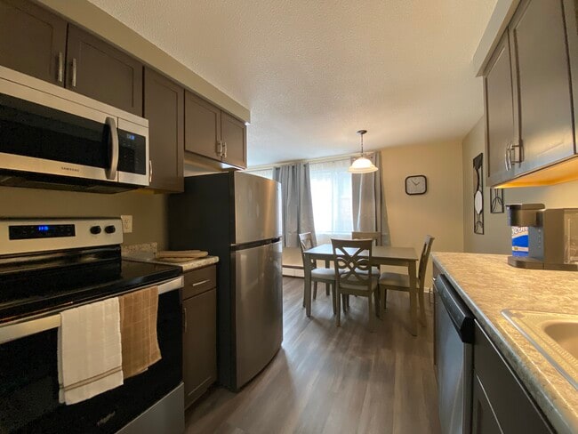 Full kitchen with large sized refrigerator, four burner stove and all dining & cookware - Avalon Apartments