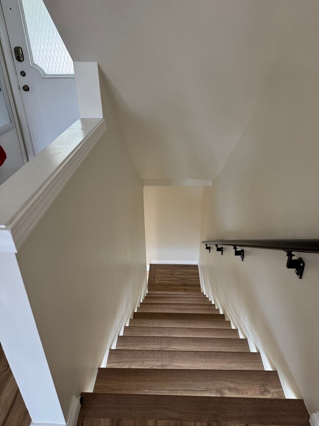 Modern wood staircase with motion-sensor LED lighting—sleek, safe, and energy-efficient design. - 328 N Allen St Unit 1