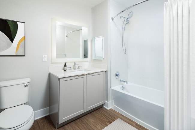 Signature Collection bath with white quartz countertop, backsplash, and hard surface flooring