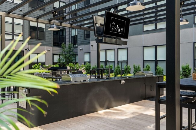 Central courtyard featuring lounge seating, bar area, outdoor tv's, and grills