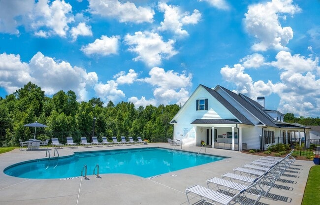 Pool off the backside of the Clubhouse that offers table seating with umbrellas.