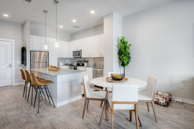 Scheme 1 kitchen with quartz countertops, tile backsplash, stainless steel appliances and hard surface flooring - Avalon Towson Apartments