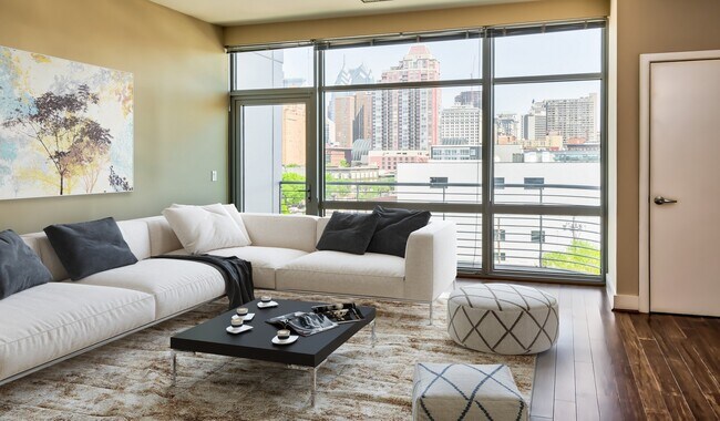 Spacious living area with floor-to-ceiling windows and wood flooring