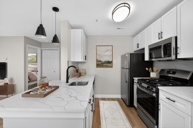 Welcome to Eagle Rock Apartments at Columbia Pike, where modern living meets convenience. This stylish kitchen features sleek appliances and beautiful finishes, perfect for culinary adventures. Explore your new home today! - Eagle Rock Apartments at Columbia Pike