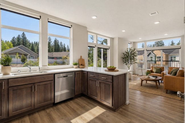 Bright, open-concept kitchen and living room with modern finishes, large windows, and a view of the neighborhood, offering a perfect blend of style and comfort.