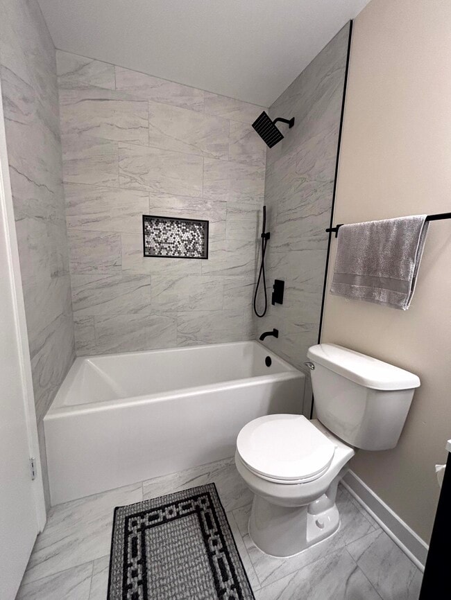 Brand new upper level bathroom with tub to ceiling tile - 4117 W Rivers Edge Cir Unit #10