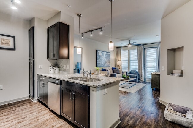 luxury kitchen with granite countertops, stainless steel appliances, and dark wood cabinetry - Junction 15