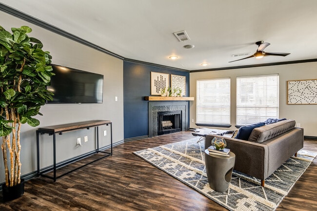 A leasing office with leather couch sitting are and cozy woodburning fireplace is shown.