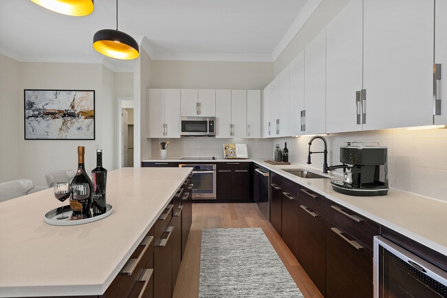 An upgraded penthouse kitchen that makes a statement—featuring expansive countertops, custom cabinetry, modern lighting, and a sleek, contemporary layout designed for elevated everyday living and effo