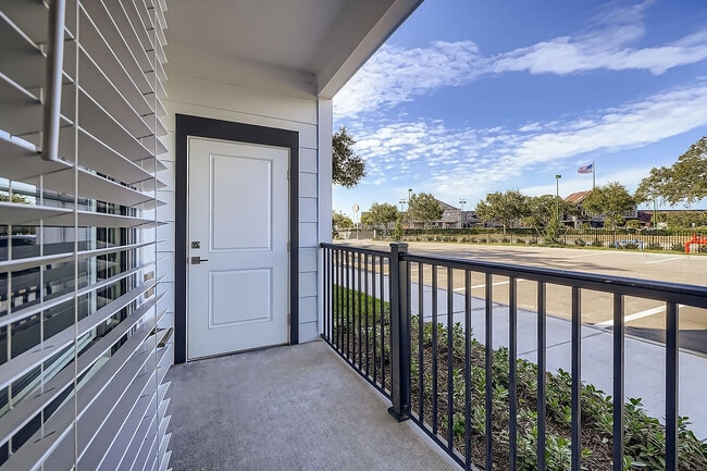 Charming apartment patio with sleek railing offering refreshing city views and blue skies.