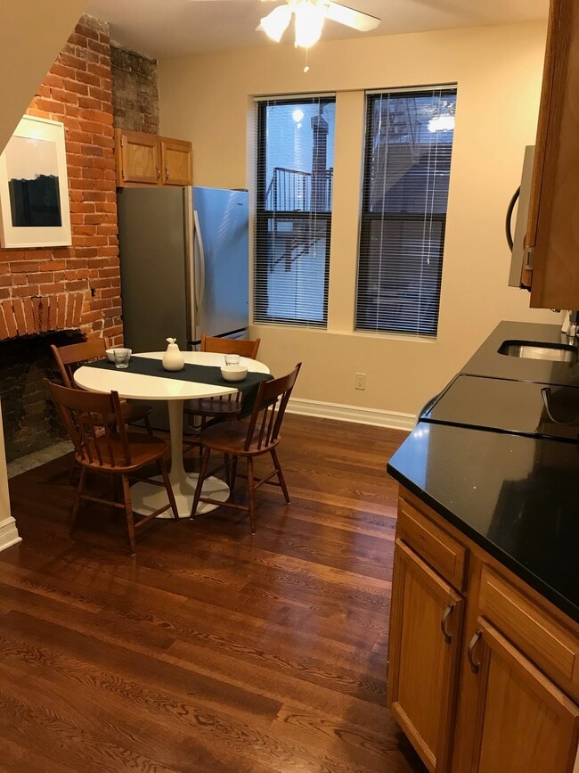 Large eat-in kitchen with dramatic brick wall - 5960 Alder St Unit Apt 2