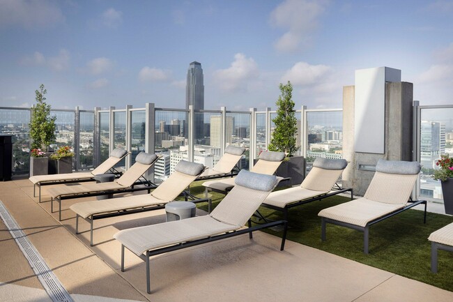 Pool deck lounge seating, BBQ grills and dining areas available - SkyHouse River Oaks Apartments