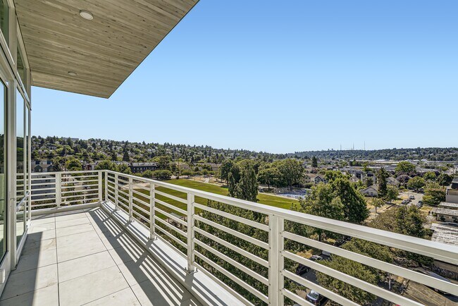 Enjoy breathtaking city views from the spacious balcony at Anker Ballard, featuring a modern railing and ample space for relaxation.