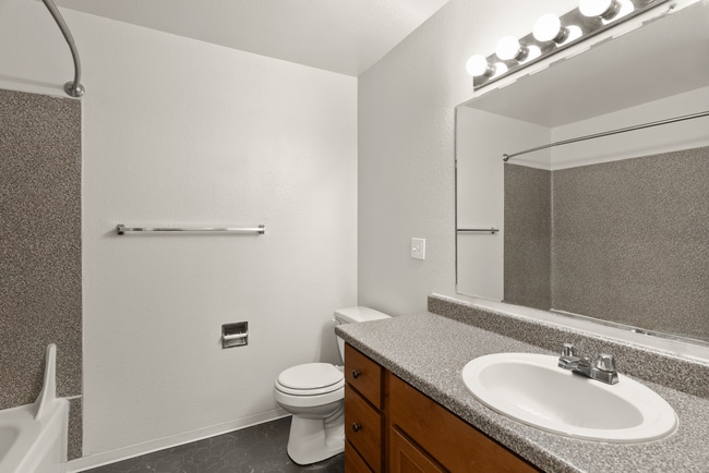 Bright bathroom with full vanity and tub.