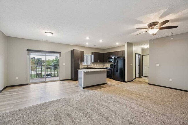 Host, relax, or unwind in this open-concept living area featuring a modern kitchen and private balcony access, designed for every lifestyle.