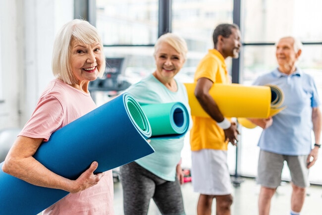 Hombres y mujeres con esterillas de yoga - The Summerfield 62+ Community
