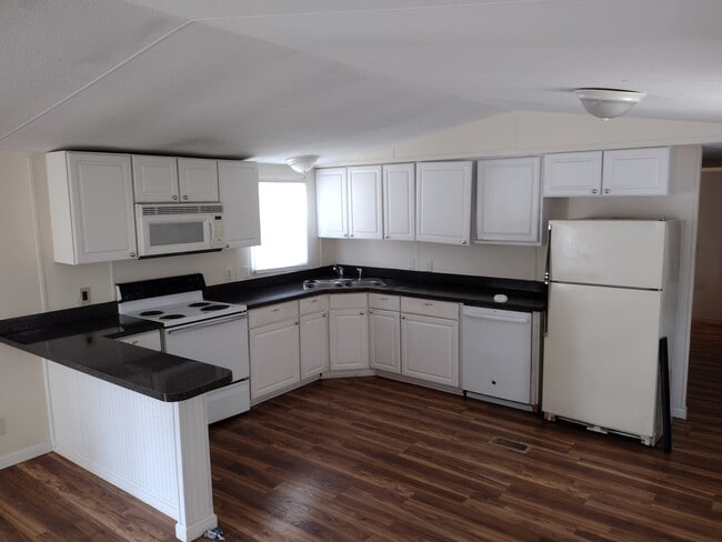 Cocina con barra de desayuno y muchos gabinetes. - 716 N Houston Lake Blvd