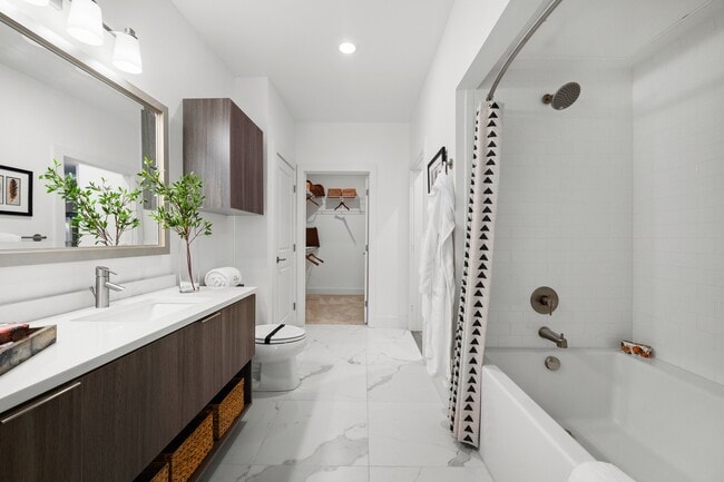 Spa inspired bathroom with dual vanity countertops, linen closet and large soaking tub