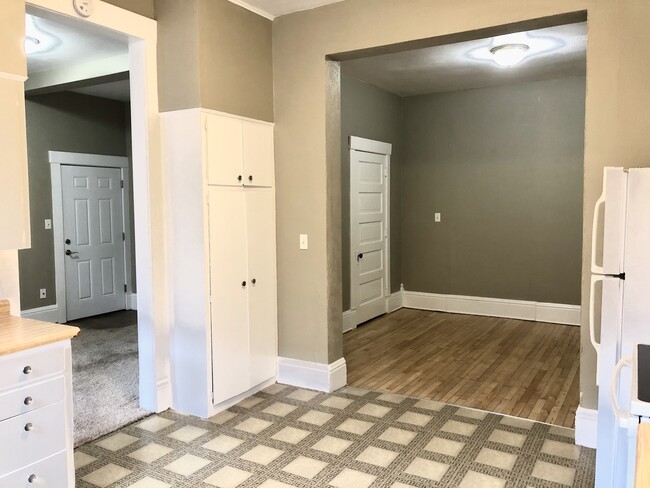 from kitchen into living area (left) and bedroom (right, hardwood) - 108 King St Apartments Unit 203