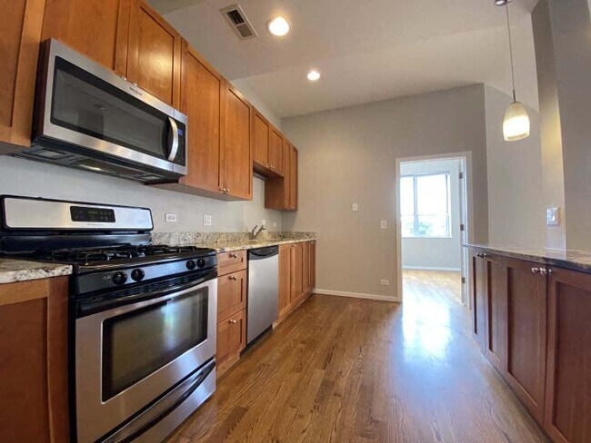 Hardwood floors, wooden cabinets, and stainless steel appliances