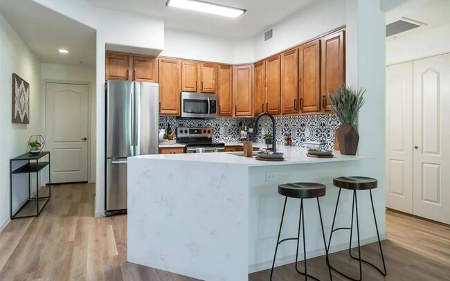 Stylish Kitchen with Stainless Steel Appliances and Bold Tile Backsplash - Desert Parks Vista