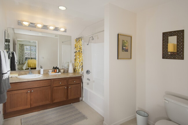 Classic Package I guest bath with maple cabinetry, beige speckled granite countertops, and tile flooring