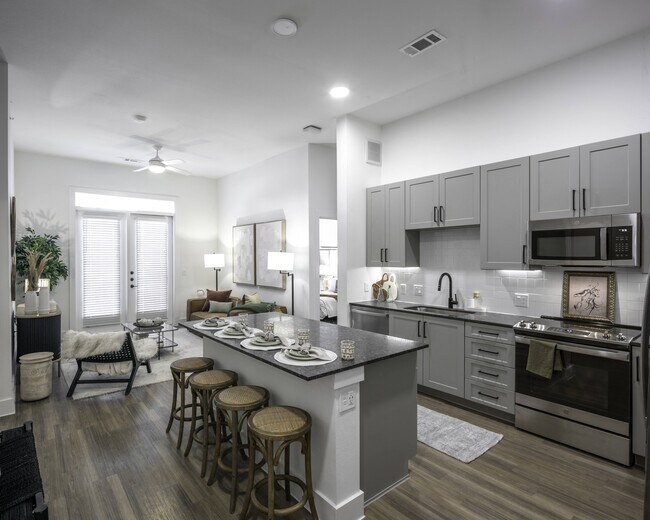 Upgrade your culinary space with stunning granite countertops and a spacious kitchen island, perfect for both style and functionality. - Modera Walsh Apartments