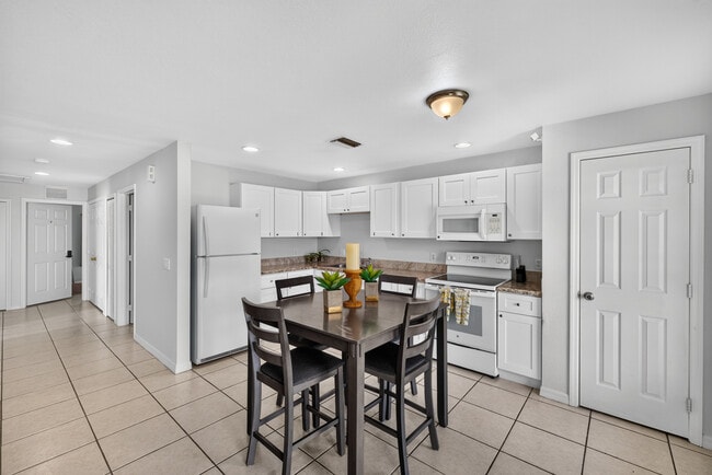 Fully-Equipped Kitchen with white, shaker-style cabinets, refrigerator, oven range & microwave