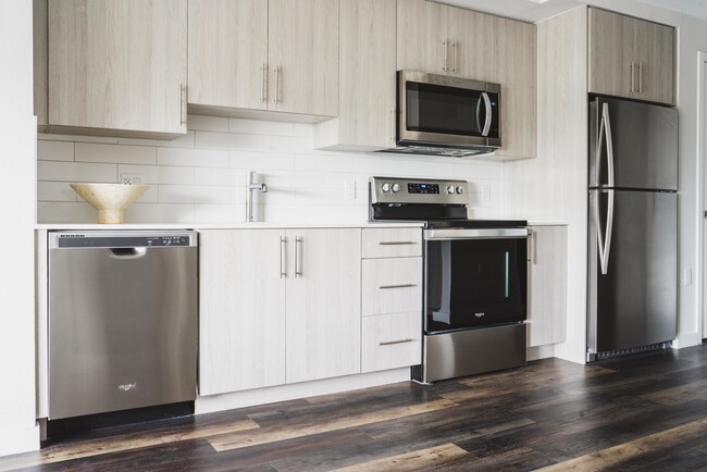 Residents can channel their inner chef in their artisan kitchen with quartz countertops and stainless-steel appliances. - Modera Skylar Apartments