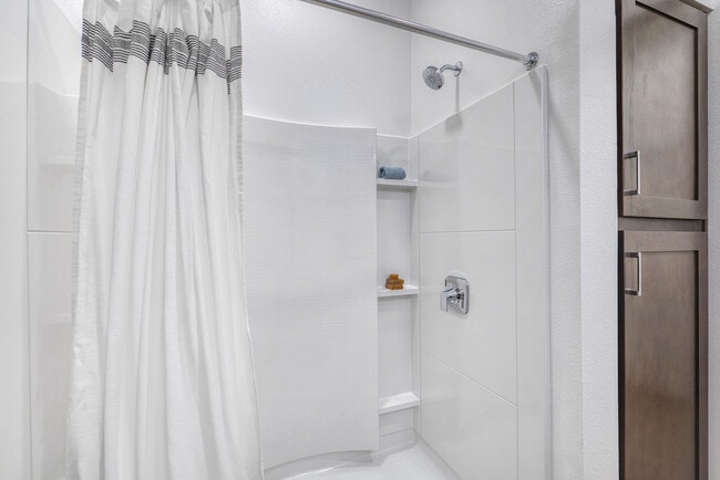 Modern shower featuring built-in shelving and contemporary finishes at Mesquite Trails at Brooks