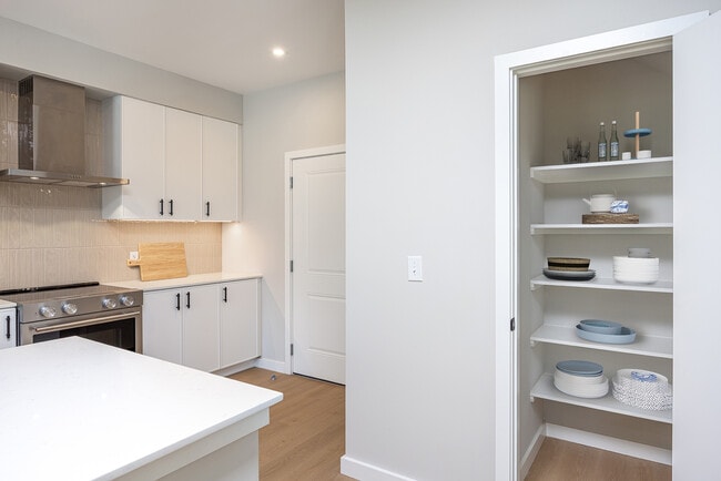 Townhome Kitchen with white cabinetry, white quartz countertops, and beige tile backsplash
