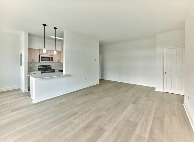 Plano de planta de concepto abierto con cocina moderna y pisos de tablones anchos en Crestwood Apartments en Wayne, PA - Crestwood