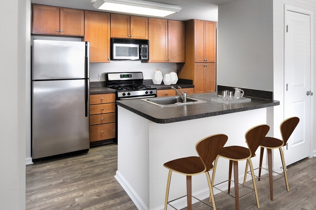 Finish Package I kitchen with oak cabinetry, black laminate countertops, stainless steel appliances, and hard surface flooring or tile